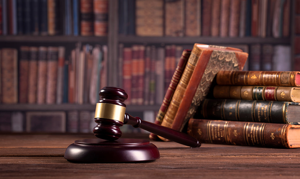 Närbild på domarklubba och lagböcker på skrivbord